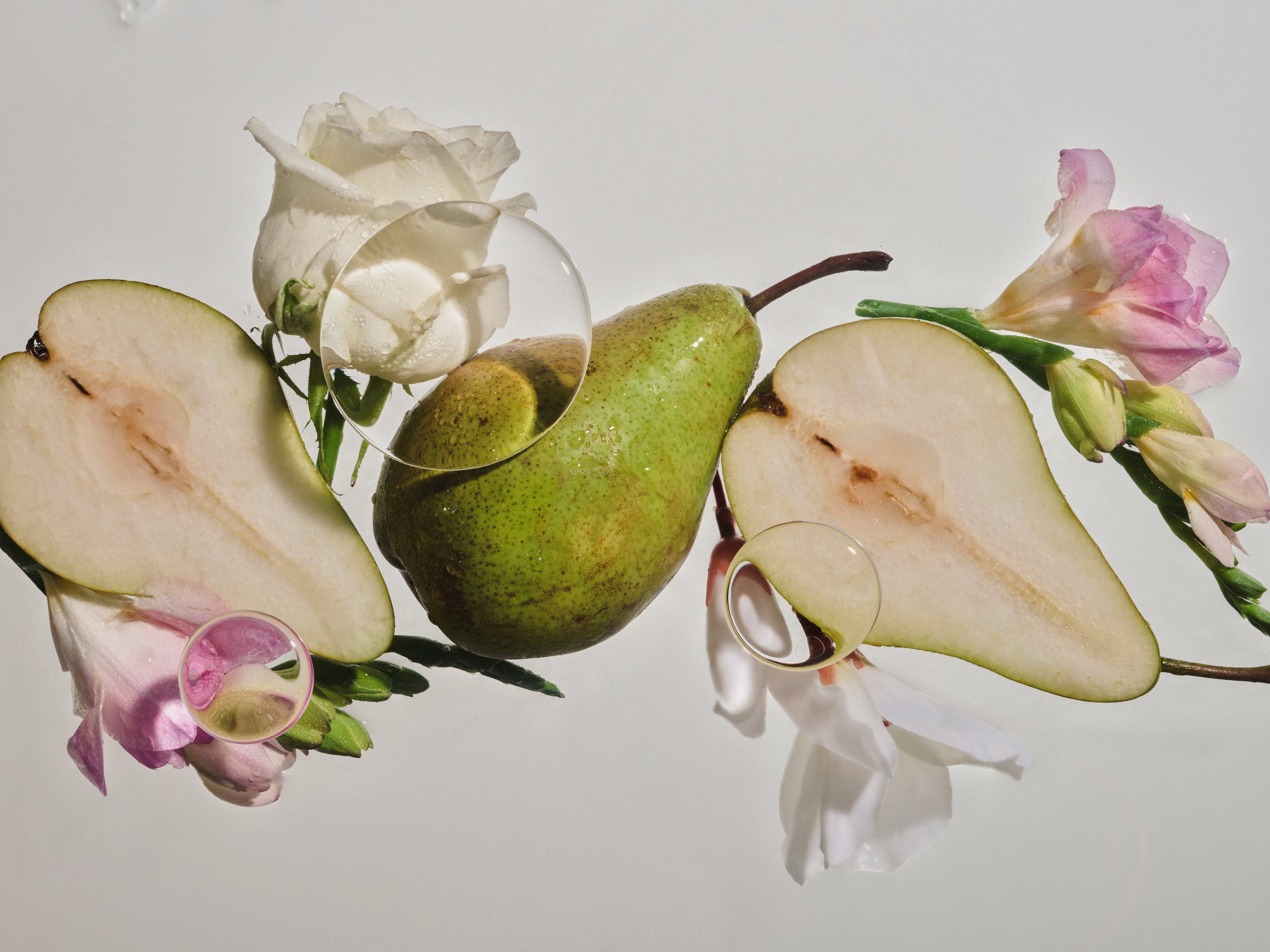 Birnen, weiße Rosen und Freesien auf hellem Hintergrund.